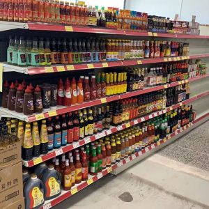 Asian grocery store aisle with soy sauce, chili sauce, and cooking condiments on shelves at Kiwi Choice New Zealand