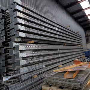 Pallet racking components and steel beams stacked in warehouse for storage system installation New Zealand