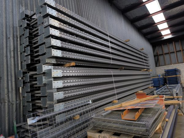 Pallet racking components and steel beams stacked in warehouse for storage system installation New Zealand